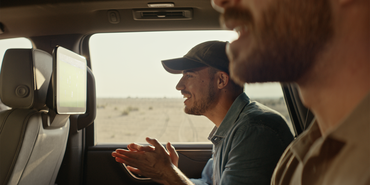 Man pressing his hands together in the backseat of the car