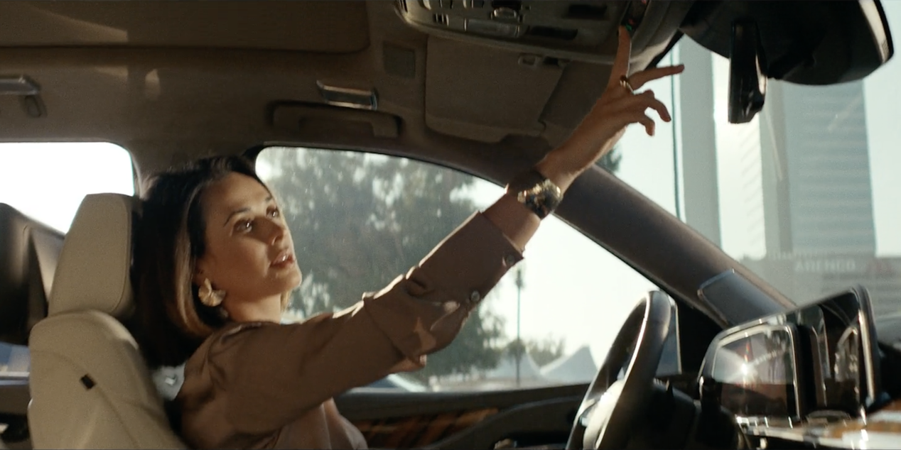 Woman in a car driving and adjusting the settings