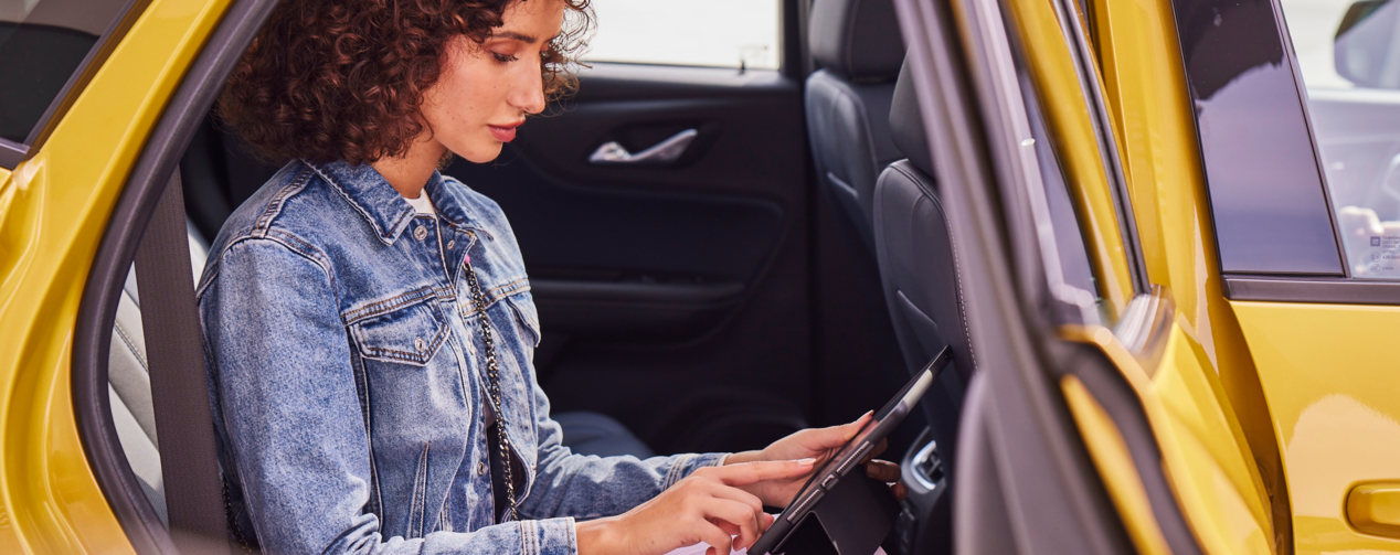 Woman on her tab in her car