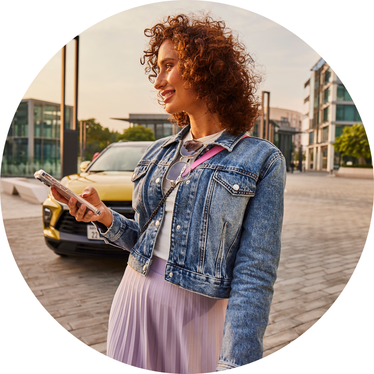 Woman with phone in front of a yellow car