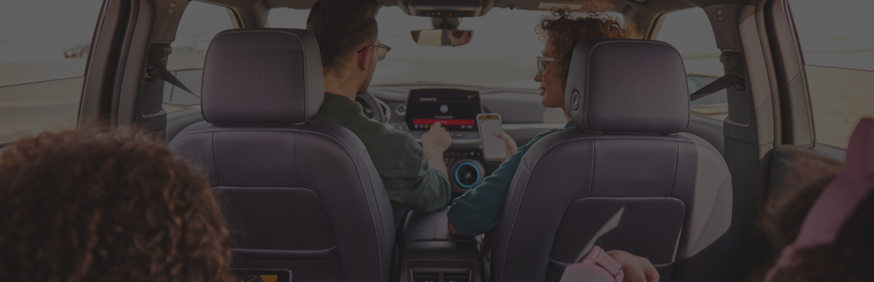 man and woman sitting inside the car and man's hand is on the infotainment