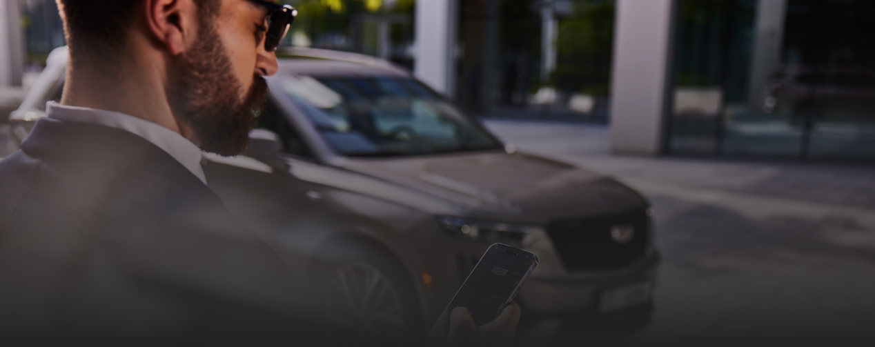 Man on phone in front of a car