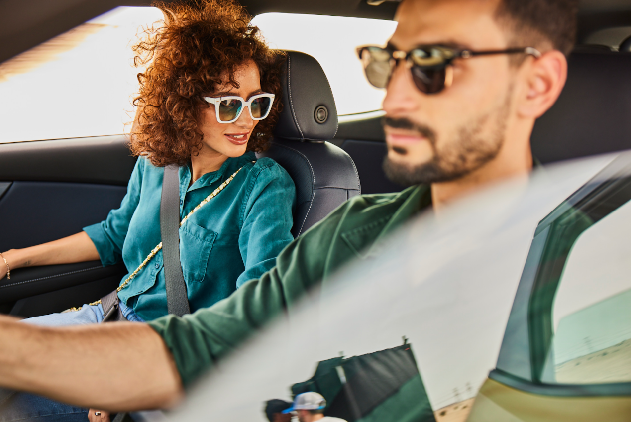 Man and woman inside the car with car window half up