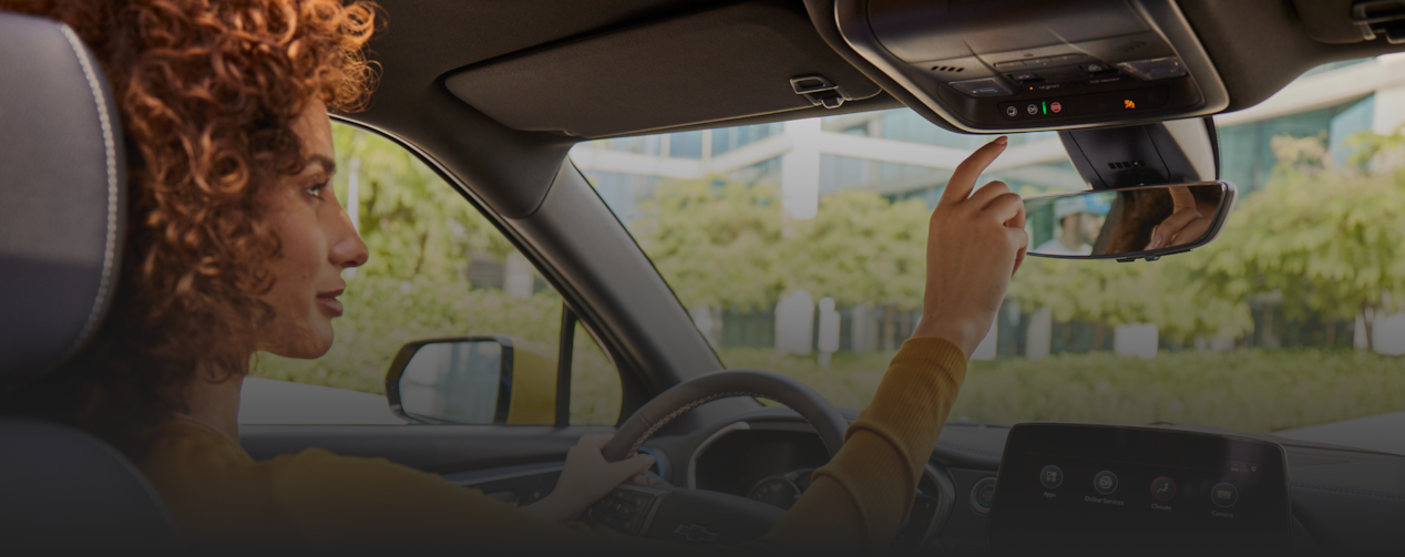 Woman inside car about to press the OnStar button