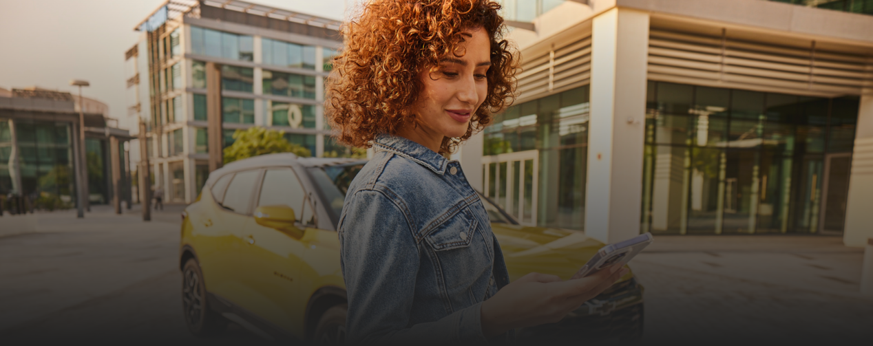 Woman beside the car and looking at the phone