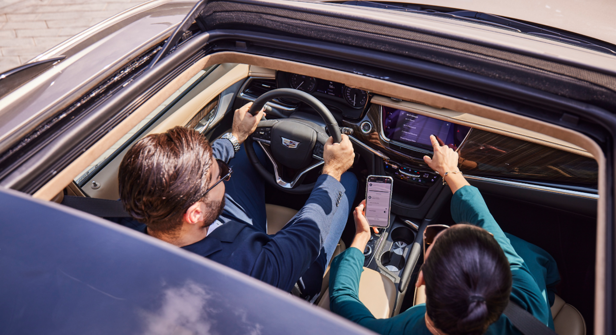 Woman pointing at the infotainment and man beside her 